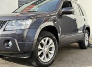 Suzuki Grand Vitara II 3.2 V6 Édition 20ème anniversaire 2009. SUV tout-terrain rare avec moteur 233 ch, intérieur cuir, toit ouvrant, caméra de recul et boîte automatique. Idéal pour les passionnés d’aventure et de véhicules robustes. Véhicule en excellent état avec suivi d’entretien